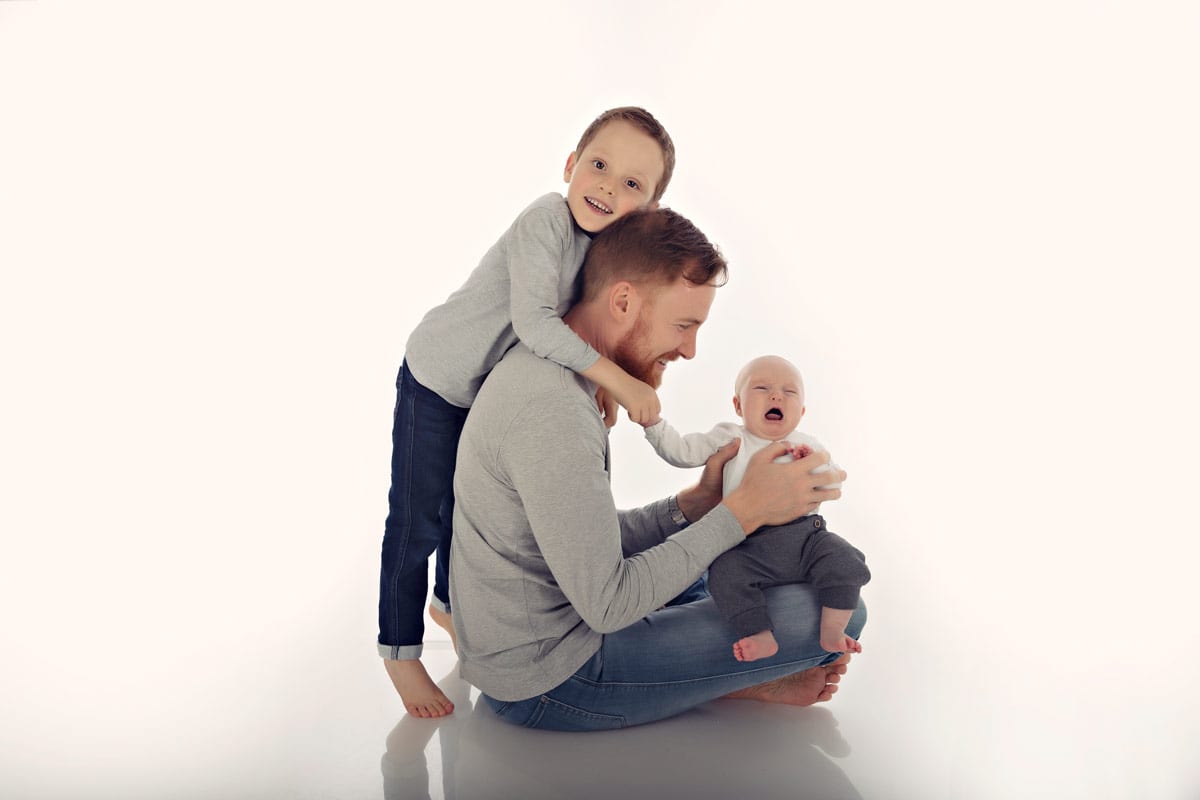 Junge haelt Vater in Familienfotos Muenchen