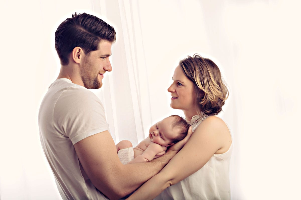Mutter Vater halten Baby waehrend Familienshooting Muenchen